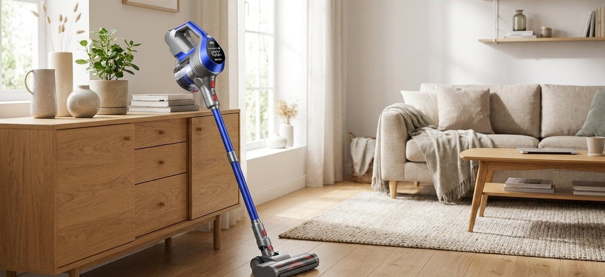 Kabelloser Akku-Staubsauger mit blauem Griff im hellen Wohnzimmer, an eine Holzkommode gelehnt