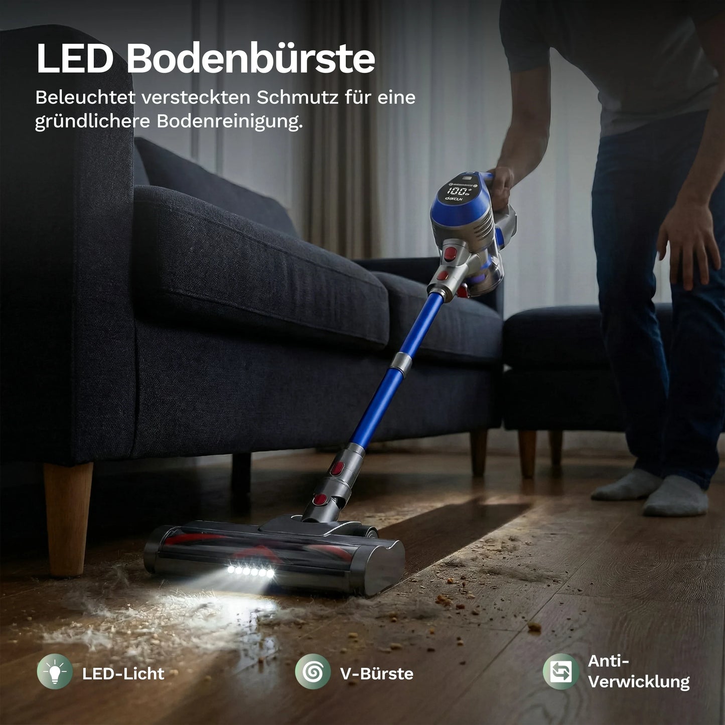 Akku-Staubsauger mit LED-Bodendüse am Sofa, blauer Griff